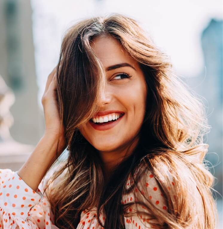Woman smiling with her hand in her hair